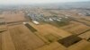 Një lagje moderne shihet jashtë kryeqytetit të Kosovës, Prishtinës, e rrethuar nga fusha me grurë.
