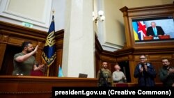 Украинският президент Володимир Зеленски ръкопляска по време на речта на британския премиер Борис Джонсън