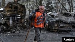 Un muncitor al serviciilor de salubrizare curăță zona lovită de o dronă rusească, în Dnipro, Ucraina, pe 9 aprilie 2025