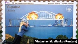 Малюнок у формі великої марки, на якій зображено Кримський міст у вогні. Центр Києва, 8 жовтні 2022 року