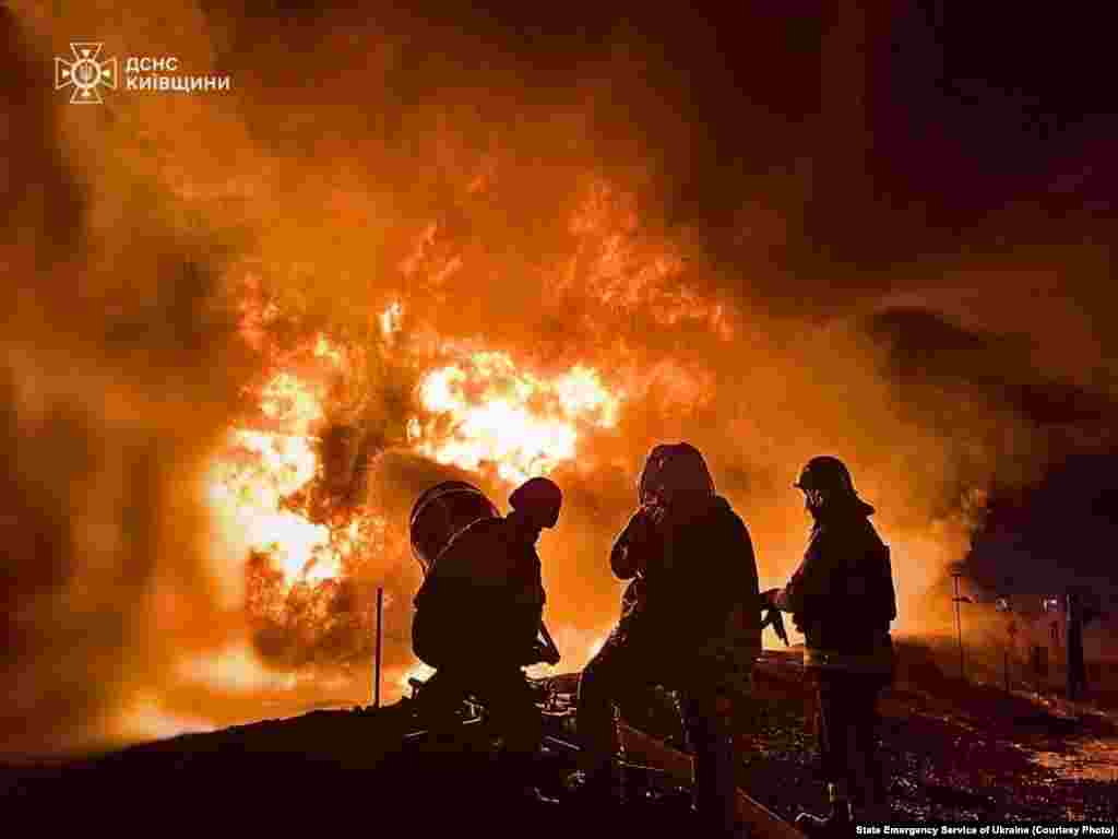Украина янгын сүндерүчелләре Русия дроны һөҗүменнән соң сәнәгать объектында чыккан янгынга каршы көрәшә, Киев өлкәсе. 