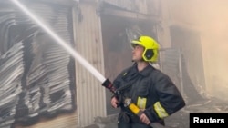 Un pompier stinge incendiile de la silozurile cu cereale lovite de rachetele și dronele rusești, Odesa, 19 iulie. 