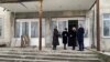Reprezentanți ai guvernului, la intrarea în clădirea liceului „Evrika” din orașul Râbnița, preluată forțat de autoritățile separatiste în 2004. Vizita a avut loc în decembrie 2021.