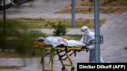 РУСИЈА - Медицинско лице придружува жена во болница каде се лекуваат пациенти од КОвид-19. 30 јуни 2021 година.