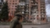 Украинский военный идет мимо жилого дома в прифронтовом Покровске, поврежденного в результате российских ударов. 6 марта 2025 года