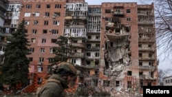 Украинский военный идет мимо жилого дома в прифронтовом Покровске, поврежденного в результате российских ударов. 6 марта 2025 года
