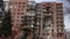 Украинский военный на фоне разрушенного при обстрелах жилого дома в Покровске (Донецкая область)