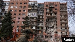 Украински војник во Покровск во близина на зграда уништена во руски напад, 6 март 2025 година.