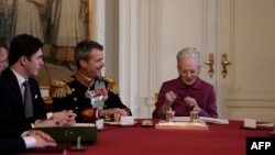 Frederik al X-lea al Danemarcei surâde mamei sale, Margrethe a II-a, care tocmai a terminat de semnat documentul prin care abdică, la castelul Christiansborg, din Copenhaga. (Foto: Claus Rasmussen / Ritzau Scanpix / AFP) 