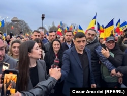 George Simion, președintele partidului AUR și candidat la alegerile prezidențiale din 4 mai, a venit pentru câteva minute la manifestația din Piața Victoriei din București, 26 martie 2025.