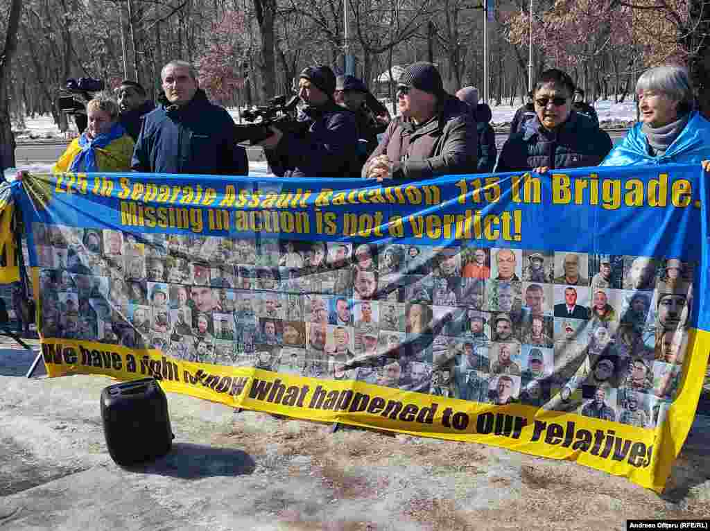 Câțiva ucraineni au adus un banner cu pozele civililor omorâți de bombele rusești. Multe dintre fotografii arată copii uciși.