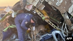 Salvatori cu câini la locul prăbușirii avionului de pasageri Azerbaijan Airlines în apropierea orașului Aktau din vestul Kazahstanului.