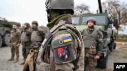 Soldați ucraineni din Brigada Mecanizată Separată 155 lângă vehicule militare, în timpul unui exercițiu de antrenament în Franța. 