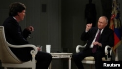 Америкалык журналист Такер Карлсон Орусиянын президенти Владимир Путинден интервью алып жатат.