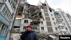 Жителка на Мариупол пред разурната зграда