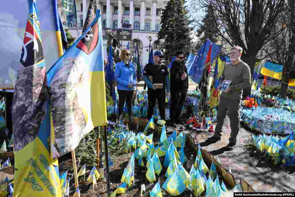 Американский бизнесмен и волонтер Билл Коул держит портрет Иэна Фрэнка Торторичи во время акции памяти шести павших американских бойцов на Майдане Независимости в Киеве 14 марта.