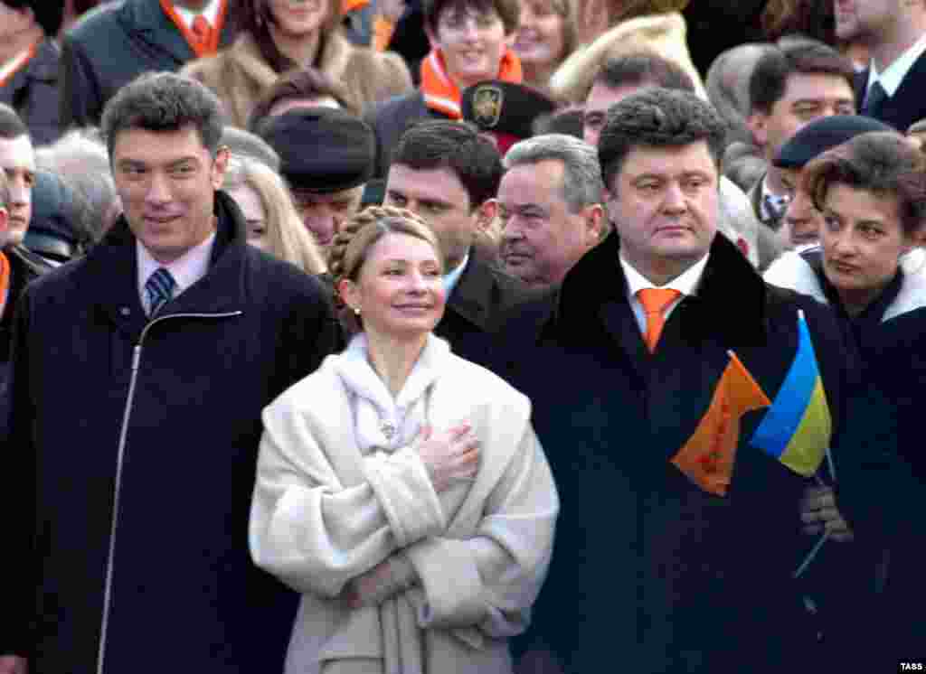 Немцов разговаря с Юлия Тимошенко на церемонията по встъпване в длъжност на украинския президент Виктор Юшченко през 2005 г. От другата ѝ страна е бизнесменът Петро Порошенко, който стана президент на Украйна през 2014 г.