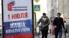 Oameni trecând pe lângă un panou publicitar în Novosibirsk. 10 iunie 2020