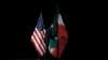 A staffer removes Iranian and US flags from the stage after a group picture with foreign ministers and representatives of Unites States, Iran, China, Russia, Britain, Germany, France and the European Union.