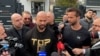 Andrew Tate (în centru) și fratele său, Tristan, în fața sediului Poliției Voluntari, unde s-au prezentat în 24 martie.