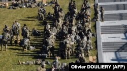 Членови на Националната гарда се одмораат пред американскиот Капитол во Вашингтон во пресрет на утрешната 59 та инагурација на новоизбраниот претседател Џо Бајден