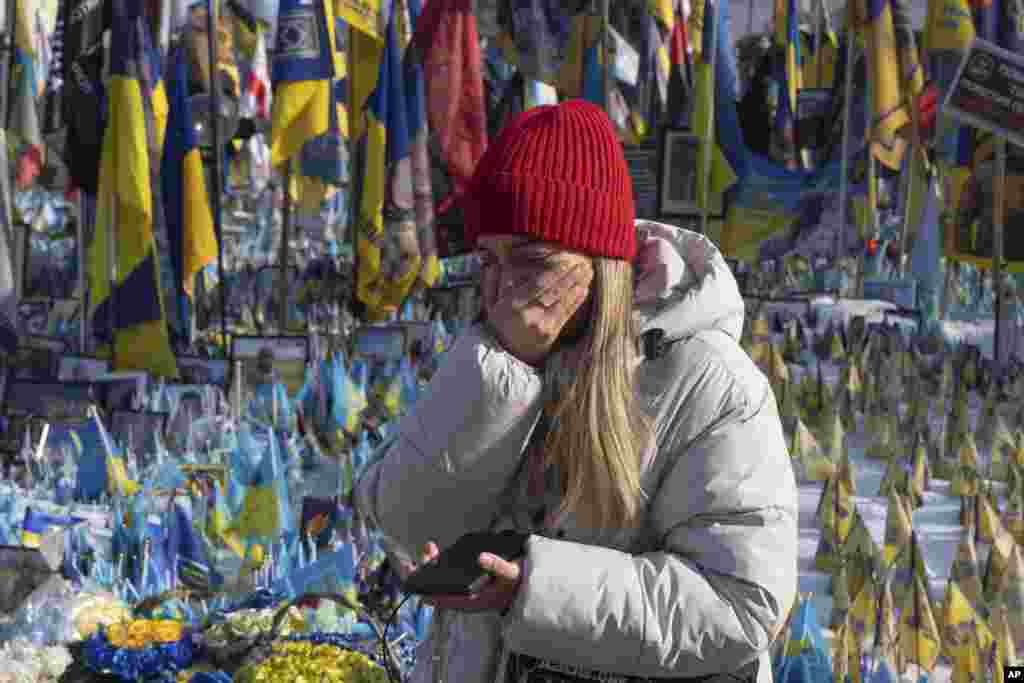 Украин кызы Киевта Бәйсезлек мәйданында һәлак булган солдатлар истәлегенә урнаштырылган мемориал янында елап тора, 24 февраль.