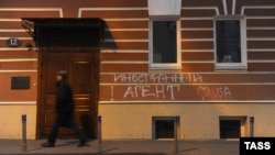 Мъж преминава покрай входа на правозащитния център "Мемориал" в Москва. На стената на сградата пише: "Чуждестранен агент" и "Обичам САЩ". 21 ноември 2012 г.