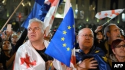 Manifestanți din Tbilisi, purtând steagurile Georgiei și Uniunii Europene, protestează fașă de adoptarea în Parlament a legii „agenților străini”. 