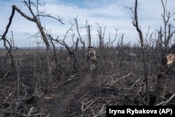 Фотографија на украински војник како се движи низ пејзажот во близина на Клишчијивка во март 2024 година