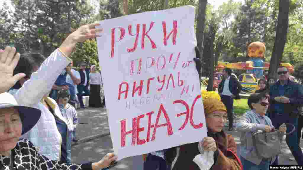 "Айгүл Ақбердіден қолыңды тарт! АЭС салынбасын" деген жазуы бар плакат ұстап тұрған азаматтар. Алматы, 1 мамыр 2019 жыл.