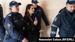 Полицейские ведут Евгению Гуцул в зал суда.